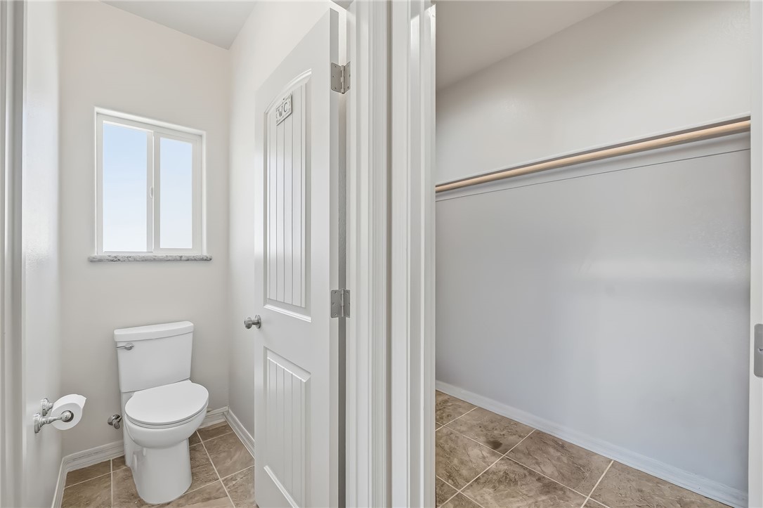 10809 North Jemez Road Kingman, AZ 86401 - Photo 46 of 51 Powder room featuring a window with a stone sill, a white toilet, and tile flooring