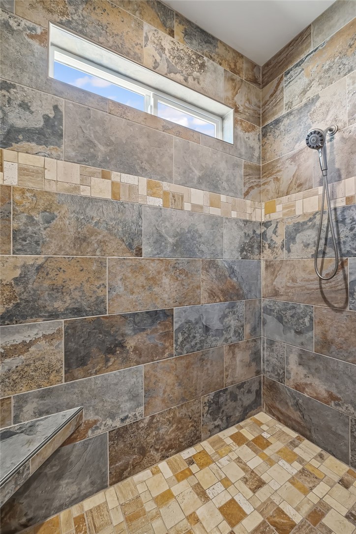 10809 North Jemez Road Kingman, AZ 86401 - Photo 47 of 51 Expansive walk-in shower featuring large format wall tiling, a decorative mosaic tile band, and a built-in corner bench