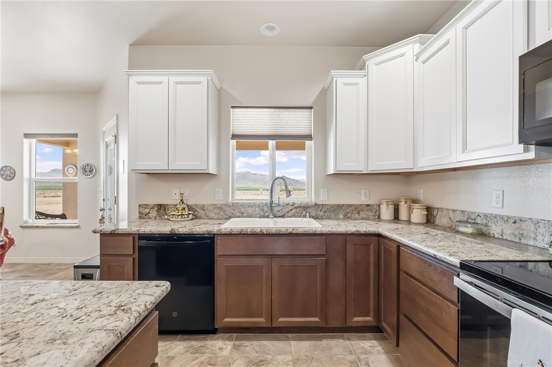 10809 North Jemez Road Kingman, AZ 86401 - Photo 8 of 51 Kitchen featuring granite countertops, two-tone cabinetry, and a stainless steel sink with a gooseneck faucet
