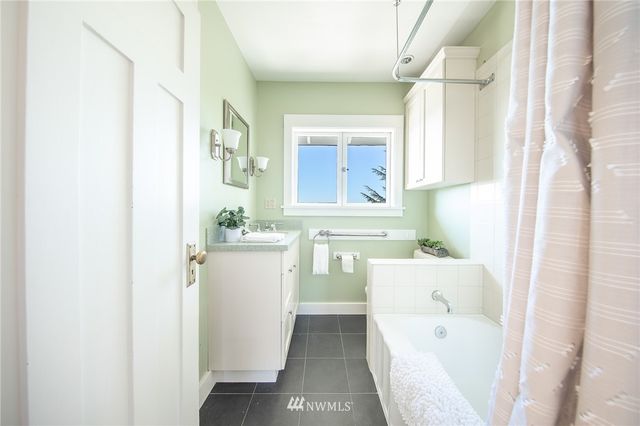 a bathroom with a bathtub sink and mirror