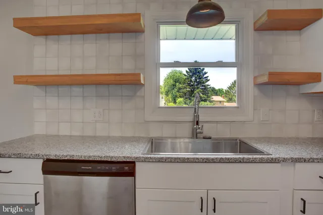 a kitchen with granite countertop a sink and a stove