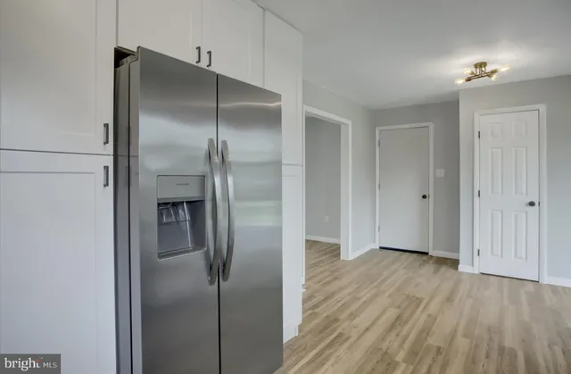 a view of a refrigerator in kitchen and a hallway
