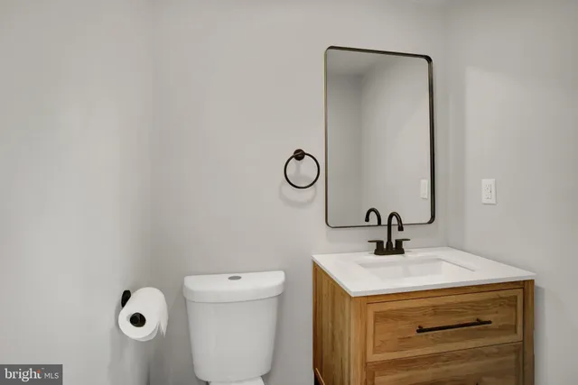 a bathroom with a sink a toilet and a mirror