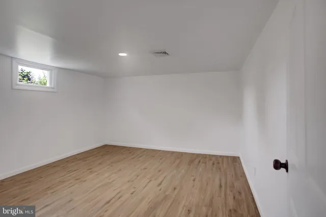 a view of a room with wooden floor and white walls