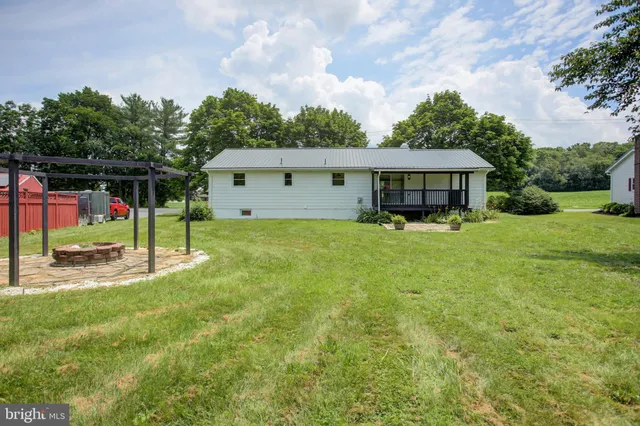 a view of a house with backyard and trees