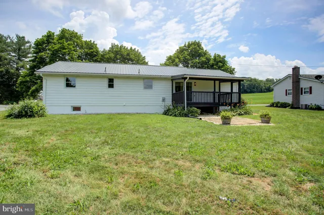 a front view of house with yard and trees in the background