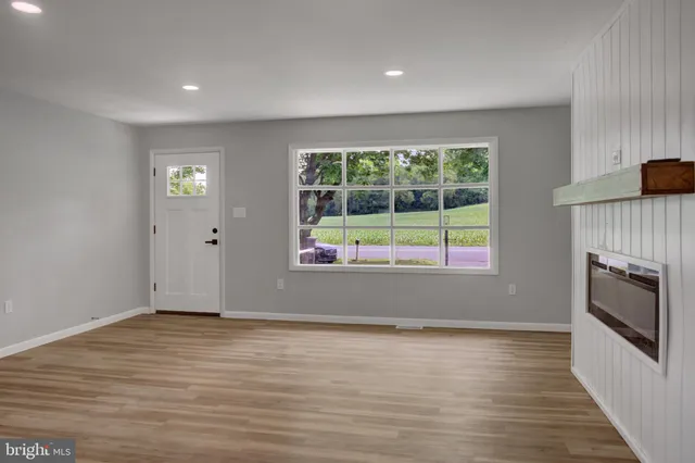 wooden floor fireplace and windows in an empty room