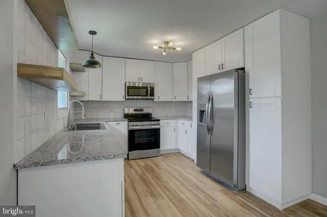 a kitchen with stainless steel appliances granite countertop a refrigerator a stove top oven a sink and dishwasher