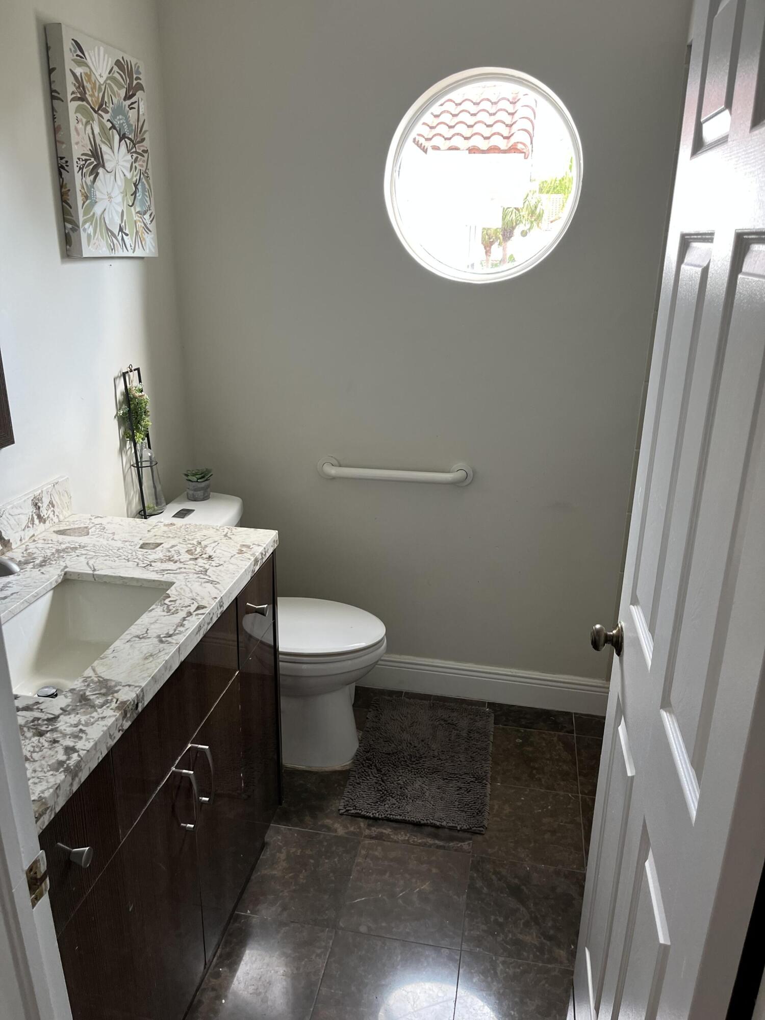 17651 Tiffany Trace Drive Boca Raton, FL 33487 - Photo 9 of 17 a bathroom with a granite countertop toilet sink and mirror