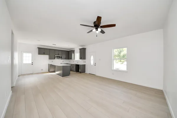 a view of a livingroom with a kitchen space with a sink dishwasher and a fireplace