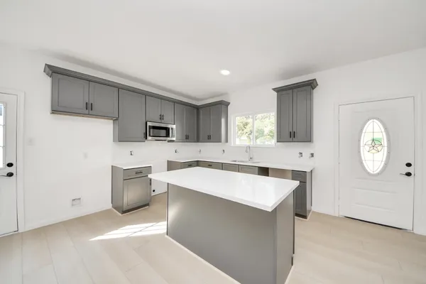 a kitchen with a sink a stove cabinets and wooden floor