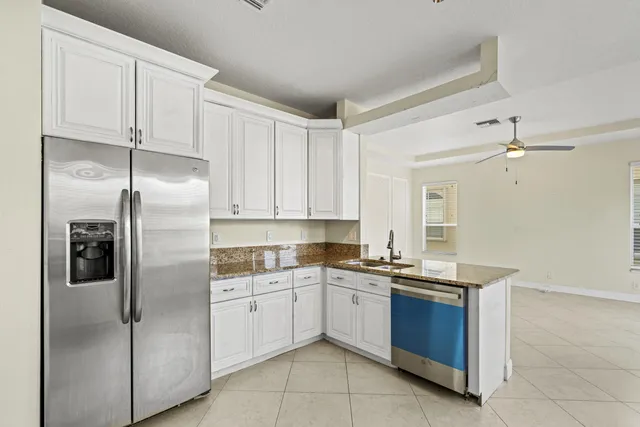 a kitchen with a refrigerator sink and cabinets