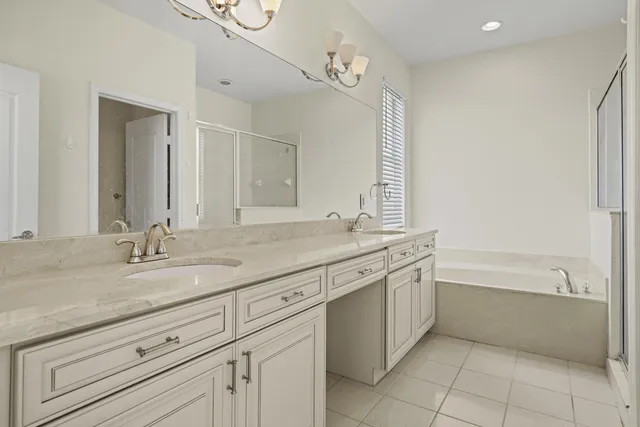 a bathroom with a tub sink and mirror