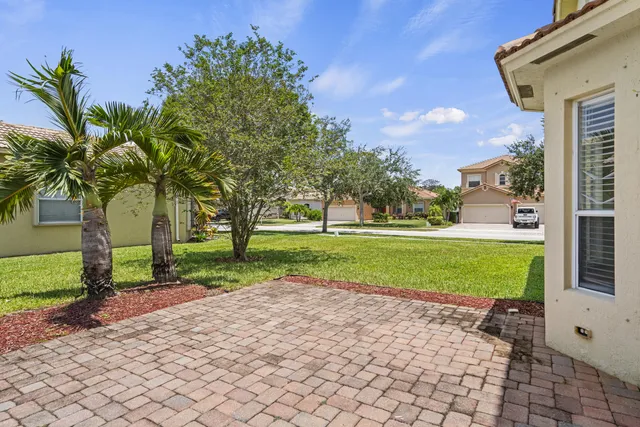 a front view of a house with a yard and potted plants