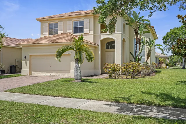 a front view of a house with a garden and plants