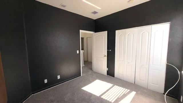 an empty room with a window and a ceiling fan