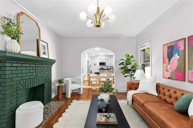 a living room with furniture a fireplace and a potted plant