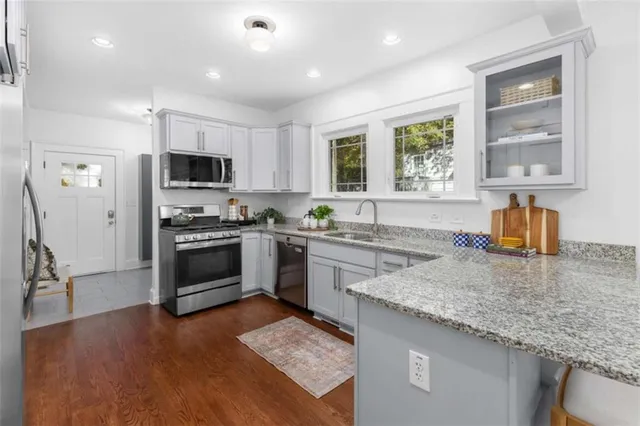 a kitchen with kitchen island granite countertop a stove sink and microwave