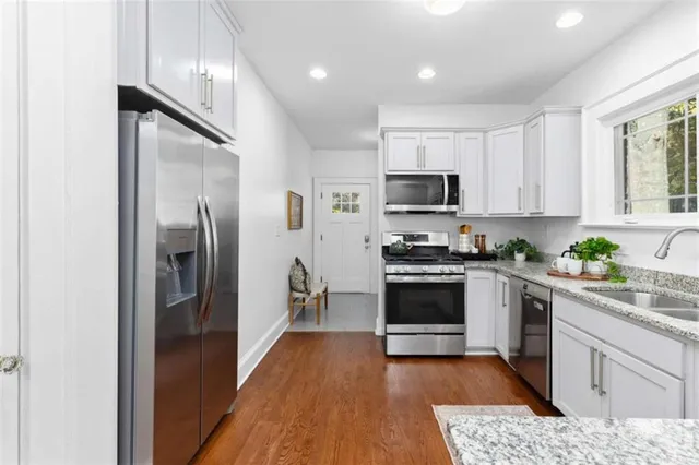 a kitchen with stainless steel appliances granite countertop a refrigerator a stove top oven a sink and dishwasher