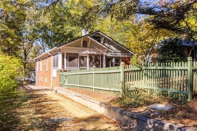 a view of a house with a small yard and wooden fence