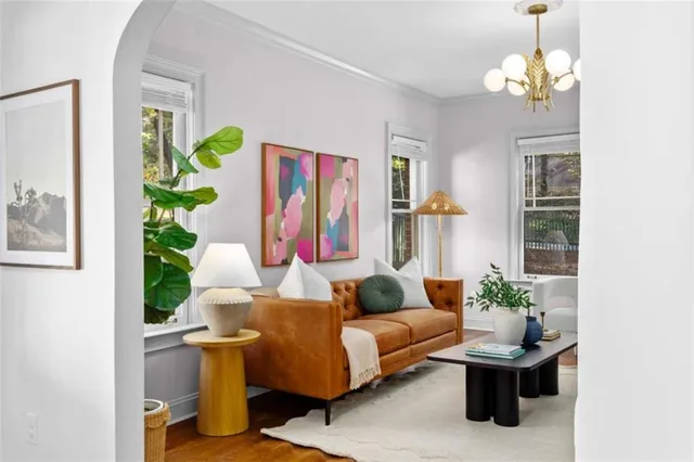 a living room with patio furniture and a potted plant