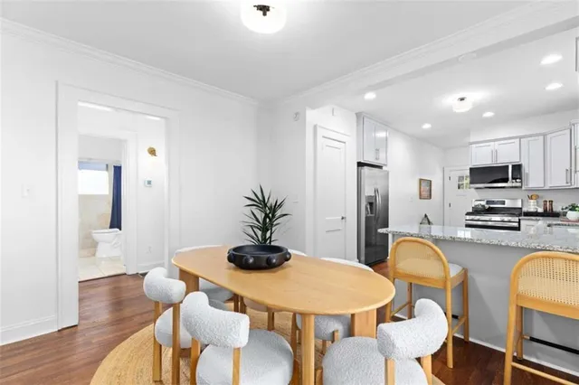 a kitchen with stainless steel appliances granite countertop a dining table and chairs