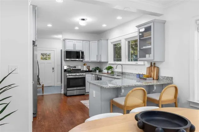 a kitchen with stainless steel appliances a stove a sink a microwave a refrigerator and cabinets