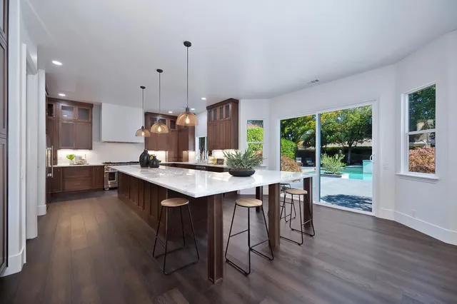 a view of a house with a big yard potted plants and large tree