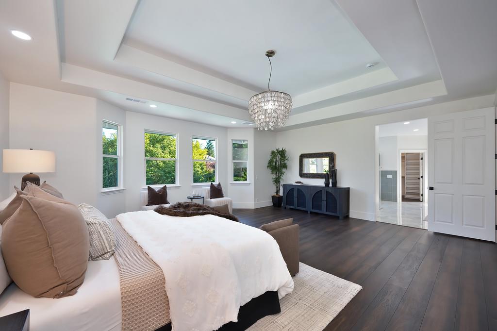 9042 Cedar Ridge Drive Granite Bay, CA 95746 - Photo 70 of 96 a spacious bedroom with a bed and wooden floor