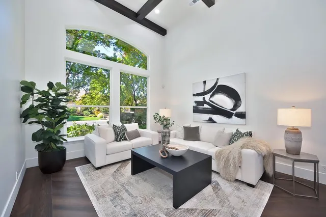 a living room with furniture kitchen view and a wooden floor