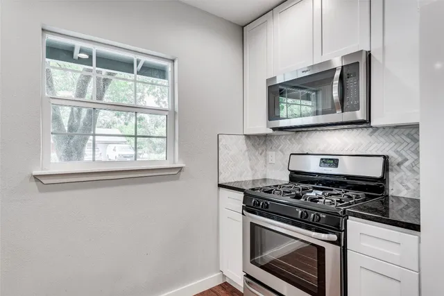 a kitchen with stainless steel appliances cabinets and a stove top oven