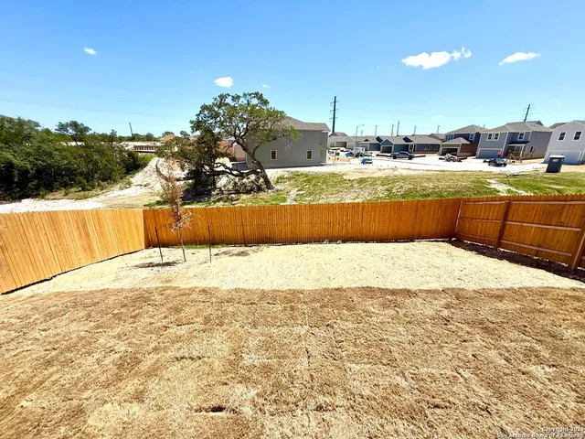 a view of a house with wooden roof and wooden fence