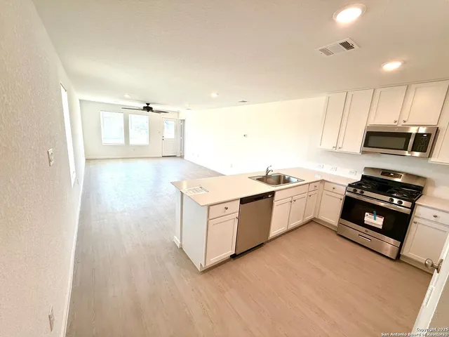 a kitchen with kitchen island white cabinets and refrigerator