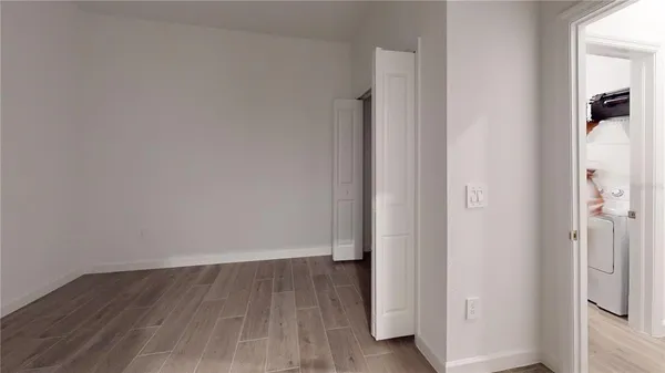 a view of a room with wooden floor and a bathroom