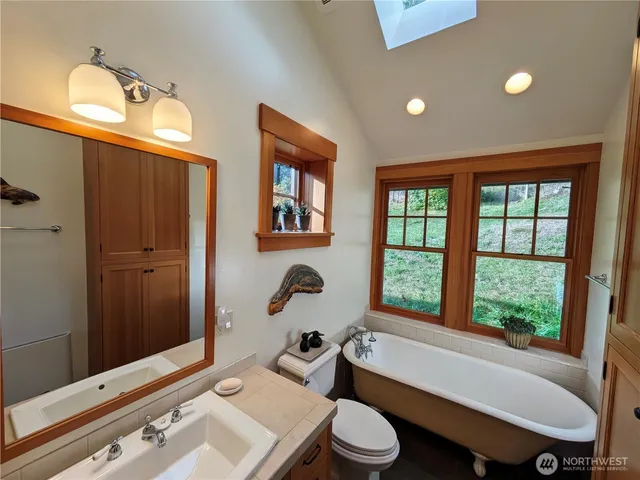 a bathroom with a sink a toilet a mirror and shower