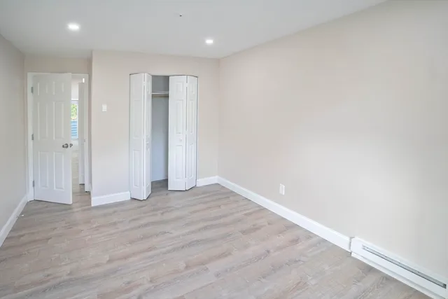a view of an empty room with wooden floor