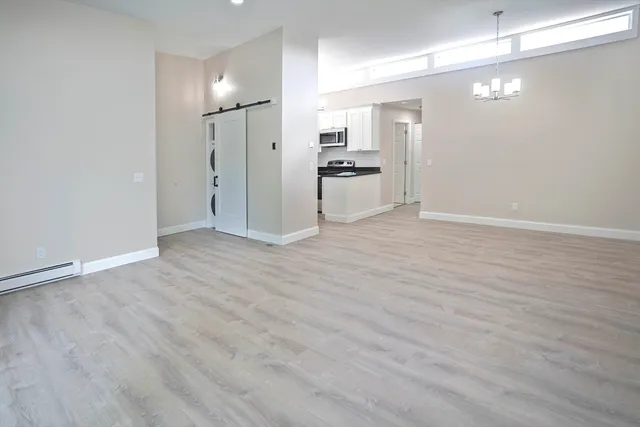 a view of a kitchen with refrigerator and wooden floor