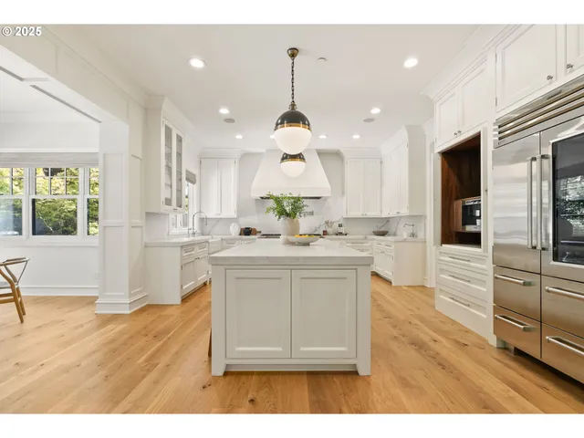 a kitchen with stainless steel appliances granite countertop a stove a sink dishwasher and a wooden floor