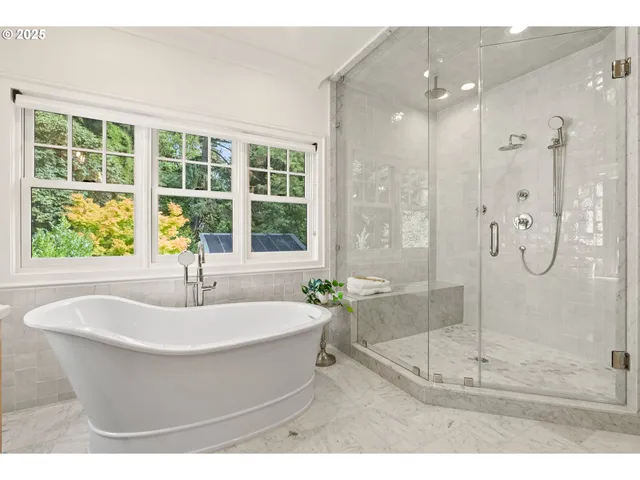 a white bath tub sitting in a bathroom next to a window