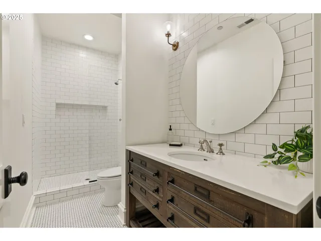 a bathroom with a sink mirror and a shower