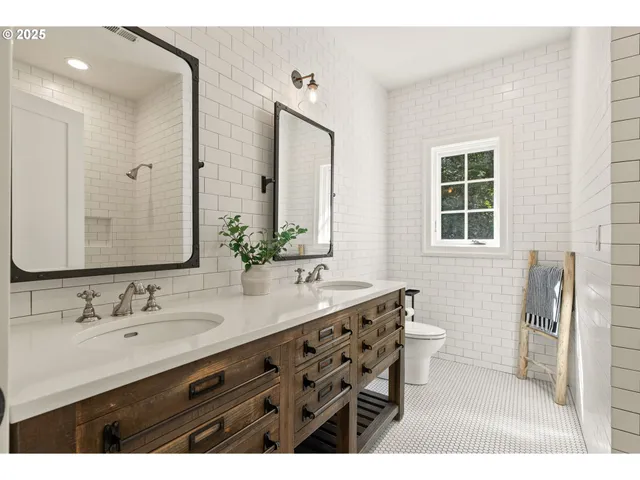 a bathroom with a sink double vanity granite tub and a mirror