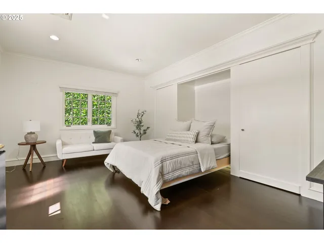 a bedroom with a large bed and a wooden floor