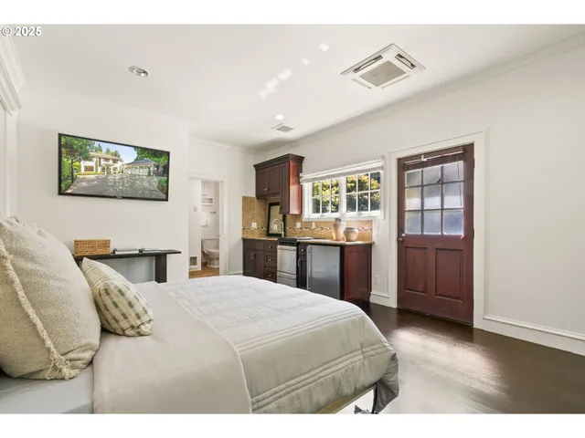 a bedroom with a bed and a refrigerator