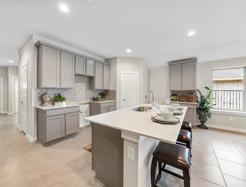 7922 Brumbly Lane Rosharon, TX 77583 - Photo 8 of 17 a kitchen with a dining table chairs sink and white cabinets