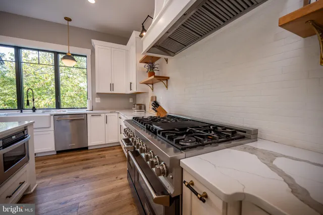 a living room with furniture a fireplace and a chandelier