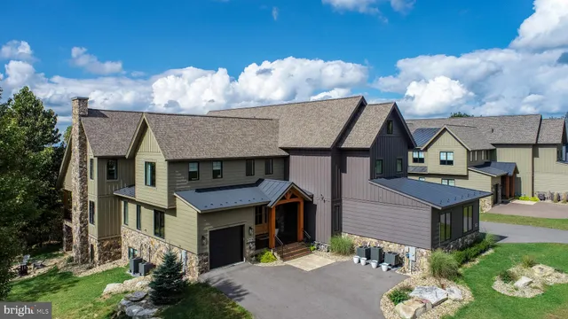an aerial view of a house with swimming pool and outdoor seating