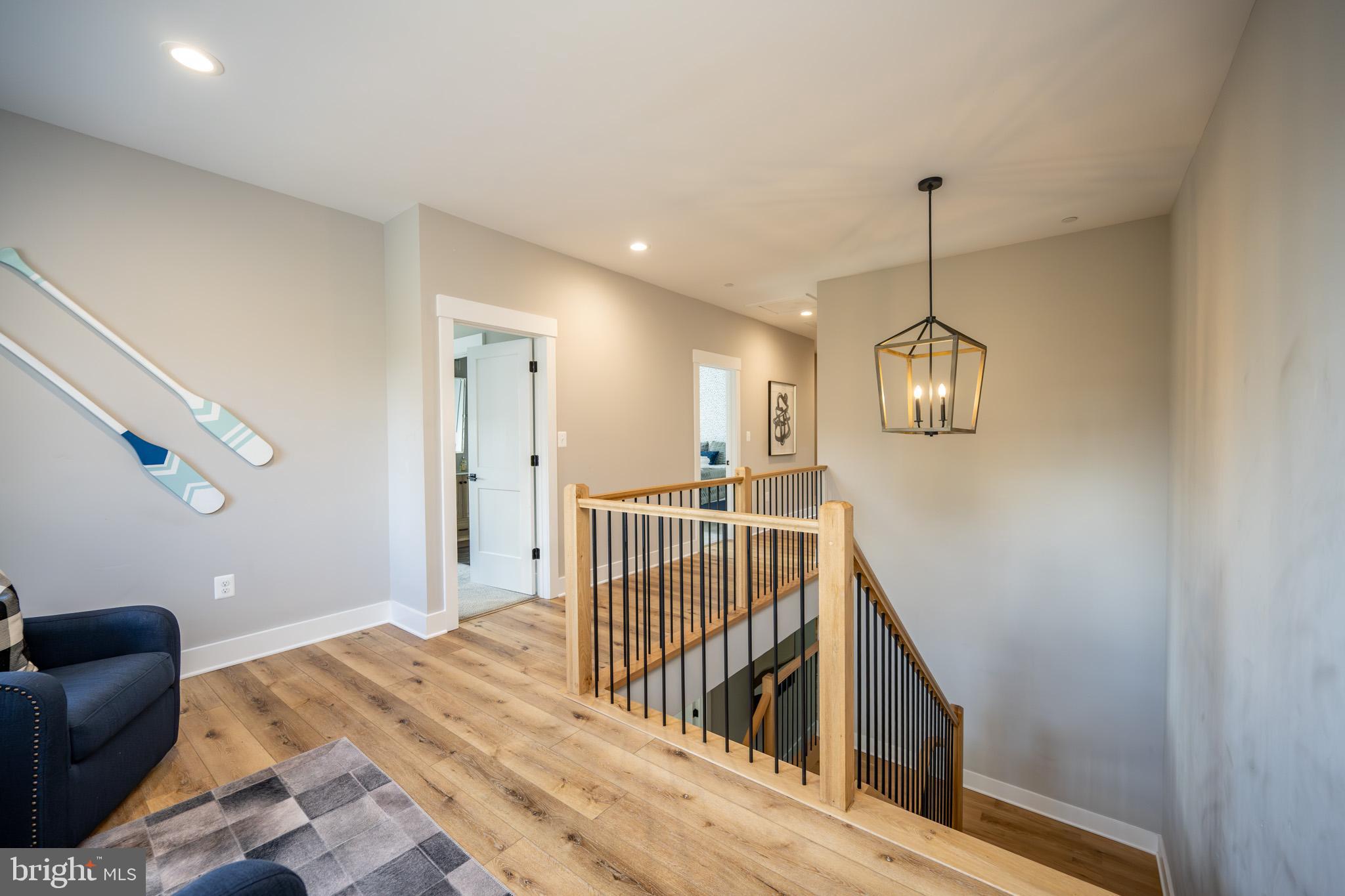 152 Ridge Run Road McHenry, MD 21541 - Photo 43 of 100 a view of a hallway to a livingroom with wooden floor stairs and a chandelier