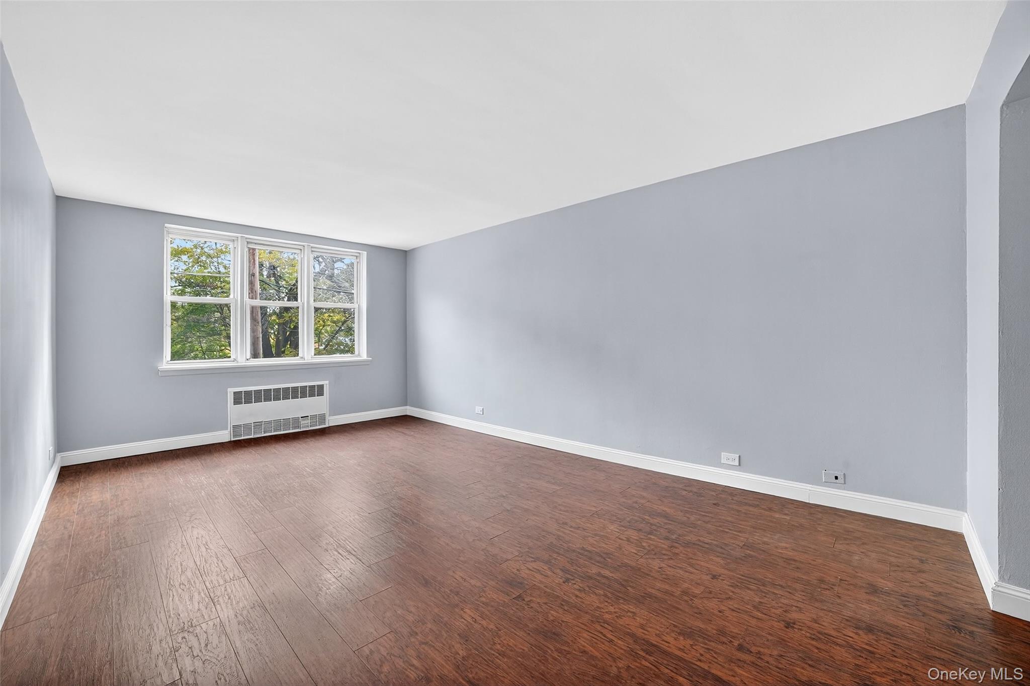 4295 Webster Avenue, Unit 1D Bronx, NY 10470 - Photo 5 of 21 an empty room with wooden floor and windows