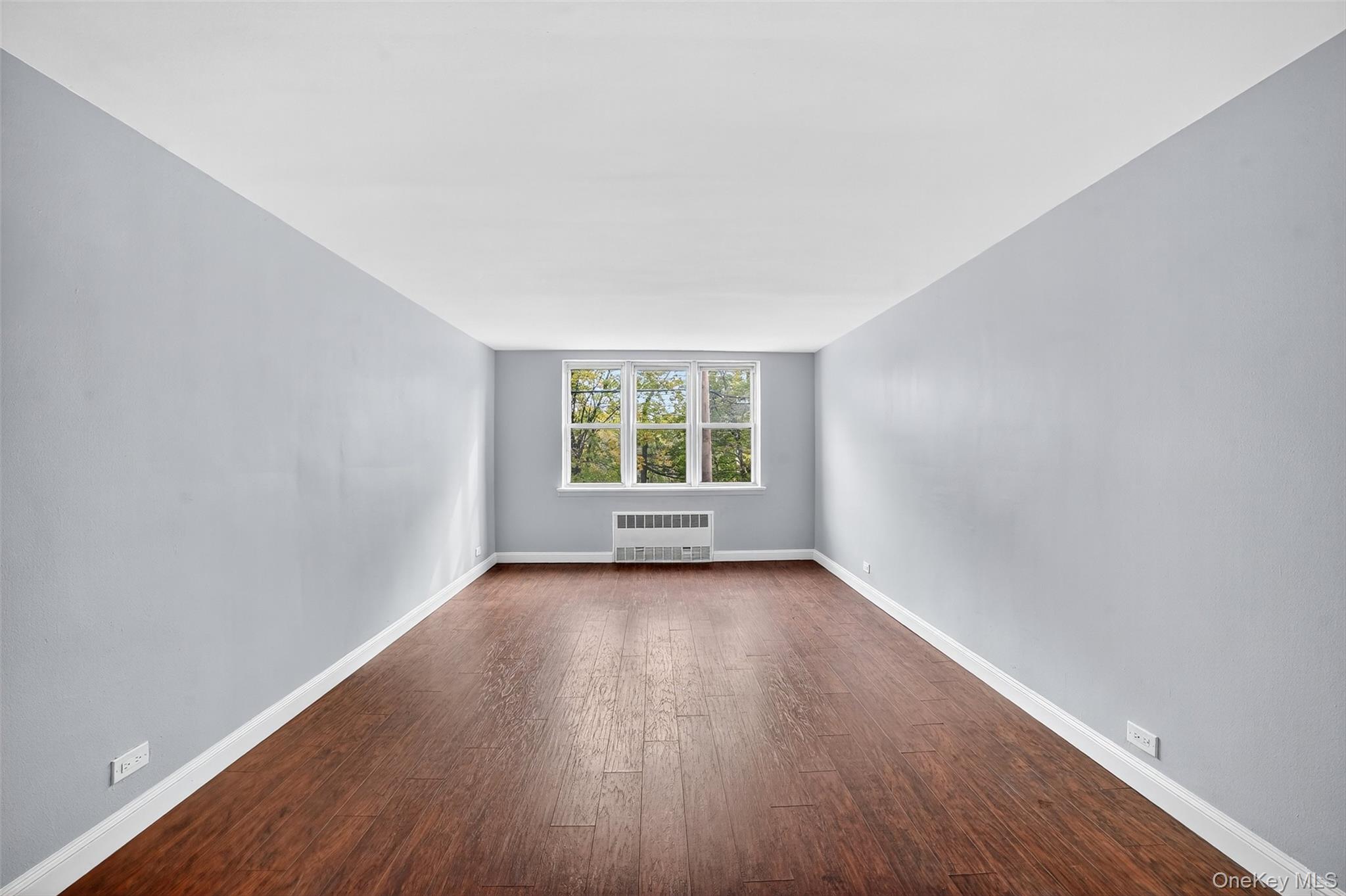 4295 Webster Avenue, Unit 1D Bronx, NY 10470 - Photo 6 of 21 an empty room with wooden floor and windows