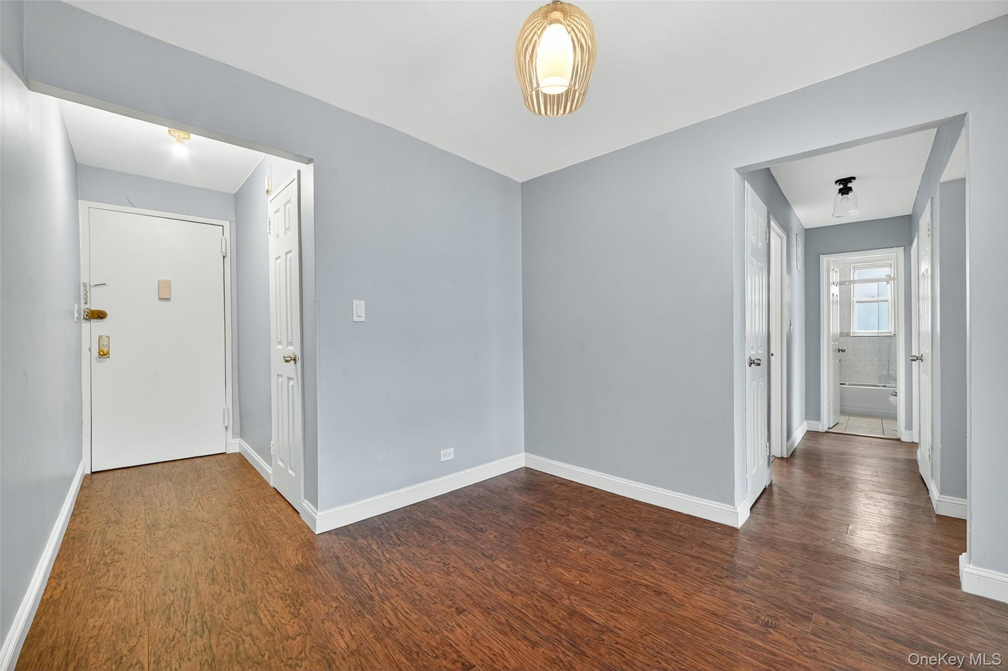 4295 Webster Avenue, Unit 1D Bronx, NY 10470 - Photo 9 of 21 an empty room with wooden floor and mirror